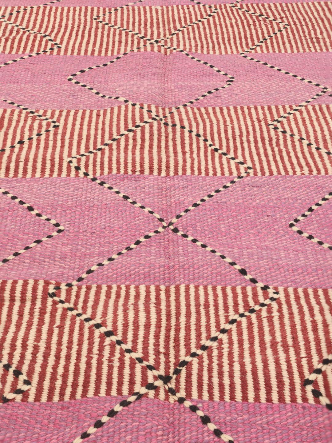 Tapis Kelim marocain tissé à la main avec des motifs géométriques en rose et rouge