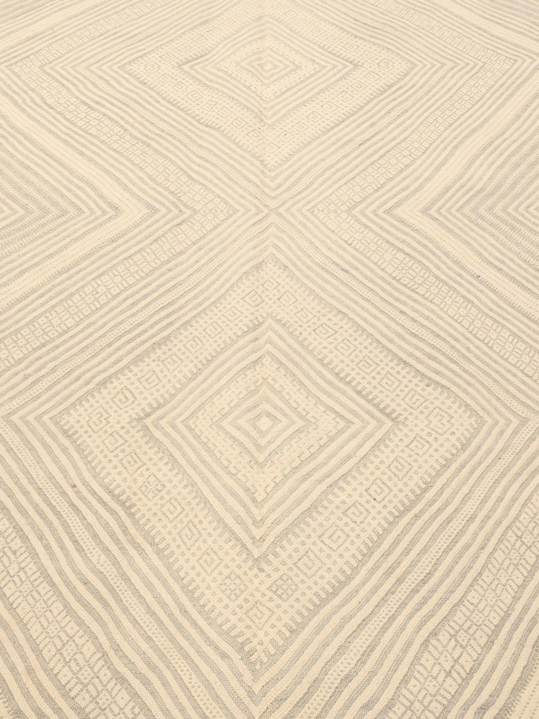 Hand-woven Moroccan rug with diamond patterns in beige and grey