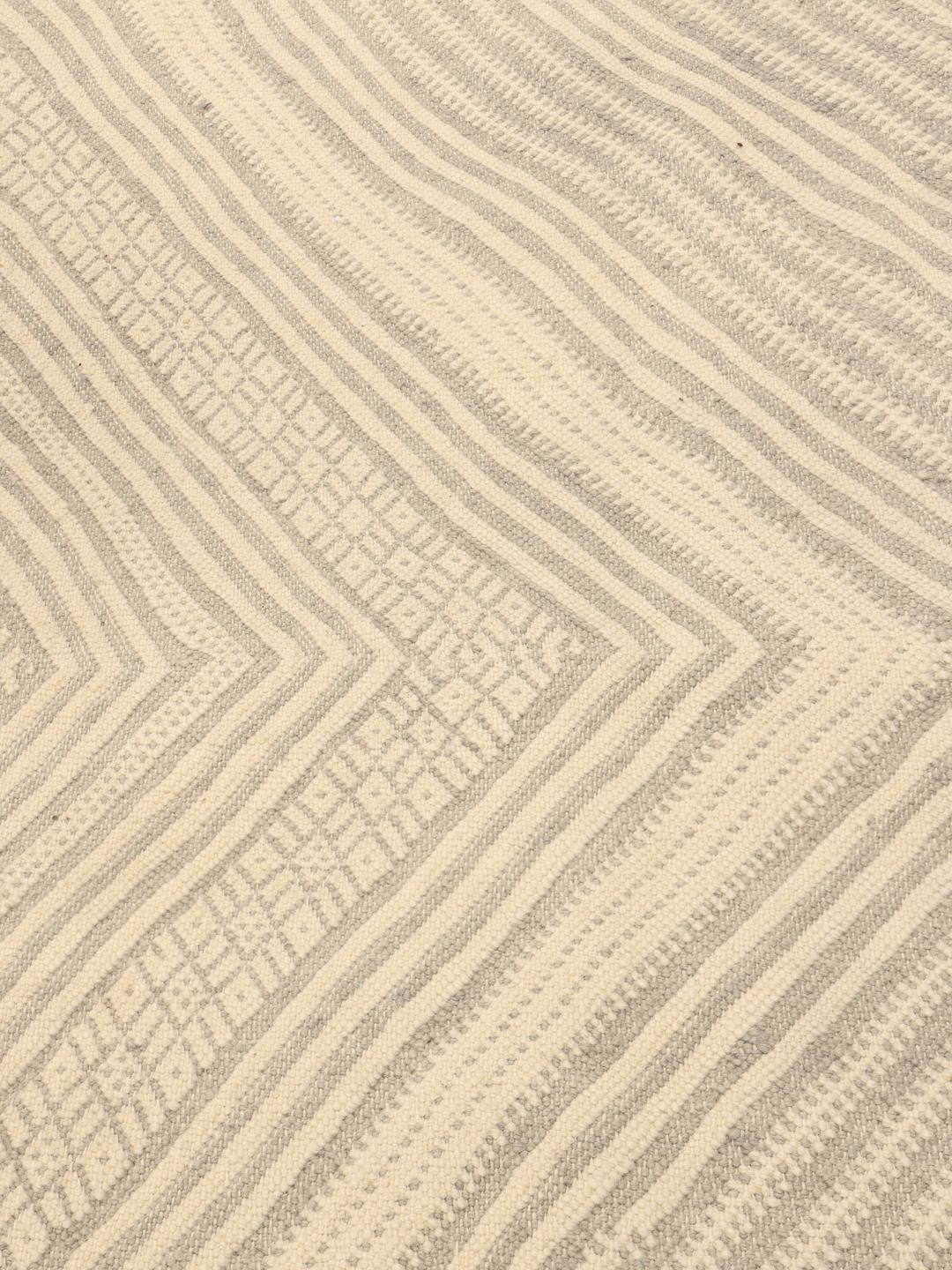 Hand-woven Moroccan rug with diamond patterns in beige and grey