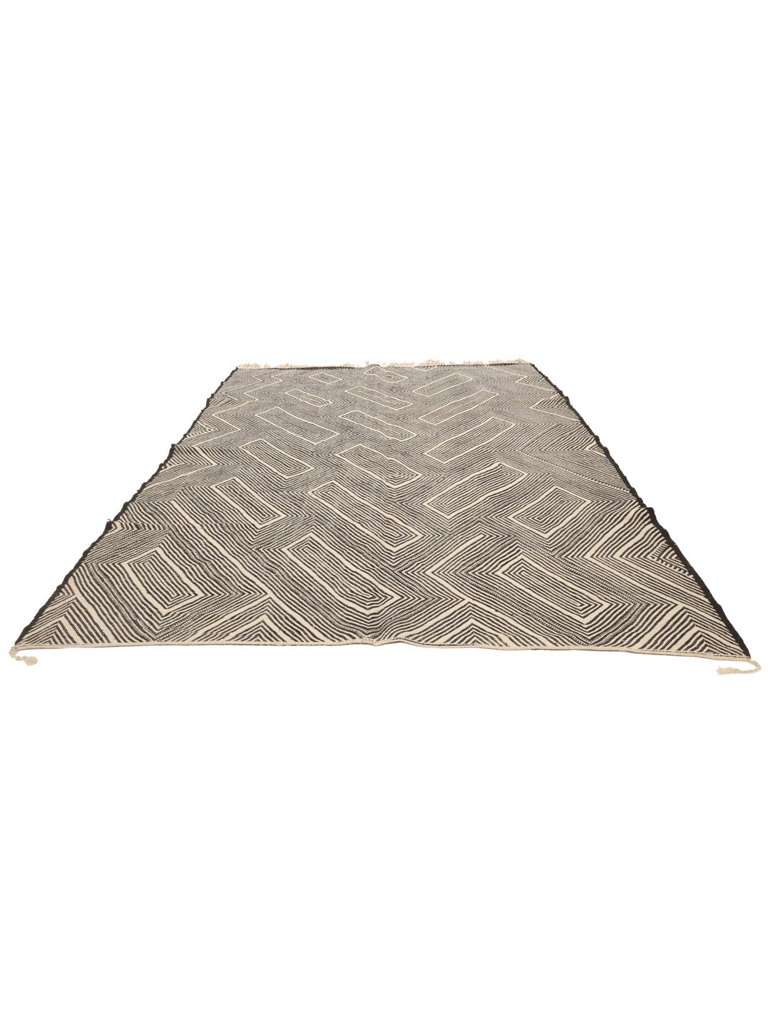 Hand-woven Moroccan High Atlas rug with geometric black and off-white patterns.