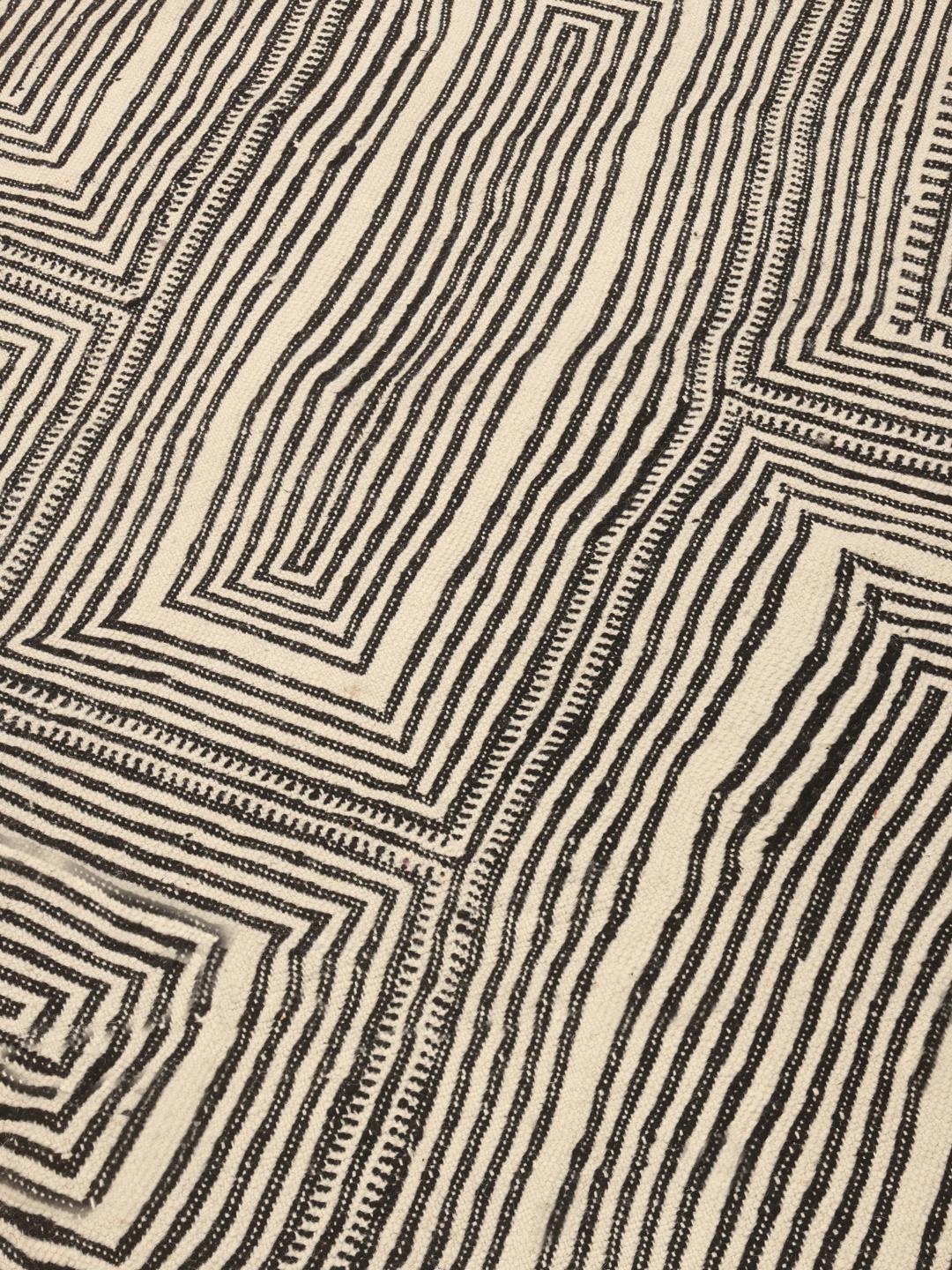 Hand-woven Moroccan High Atlas rug with geometric black and off-white patterns.