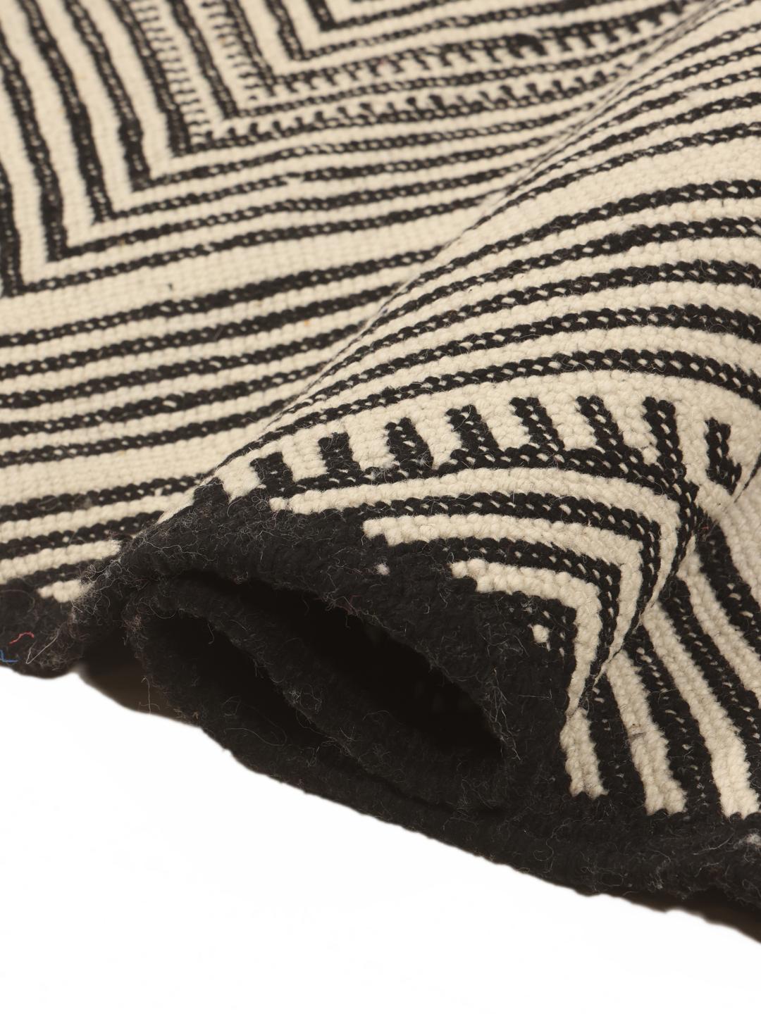 Hand-woven Moroccan High Atlas rug with geometric black and off-white patterns.
