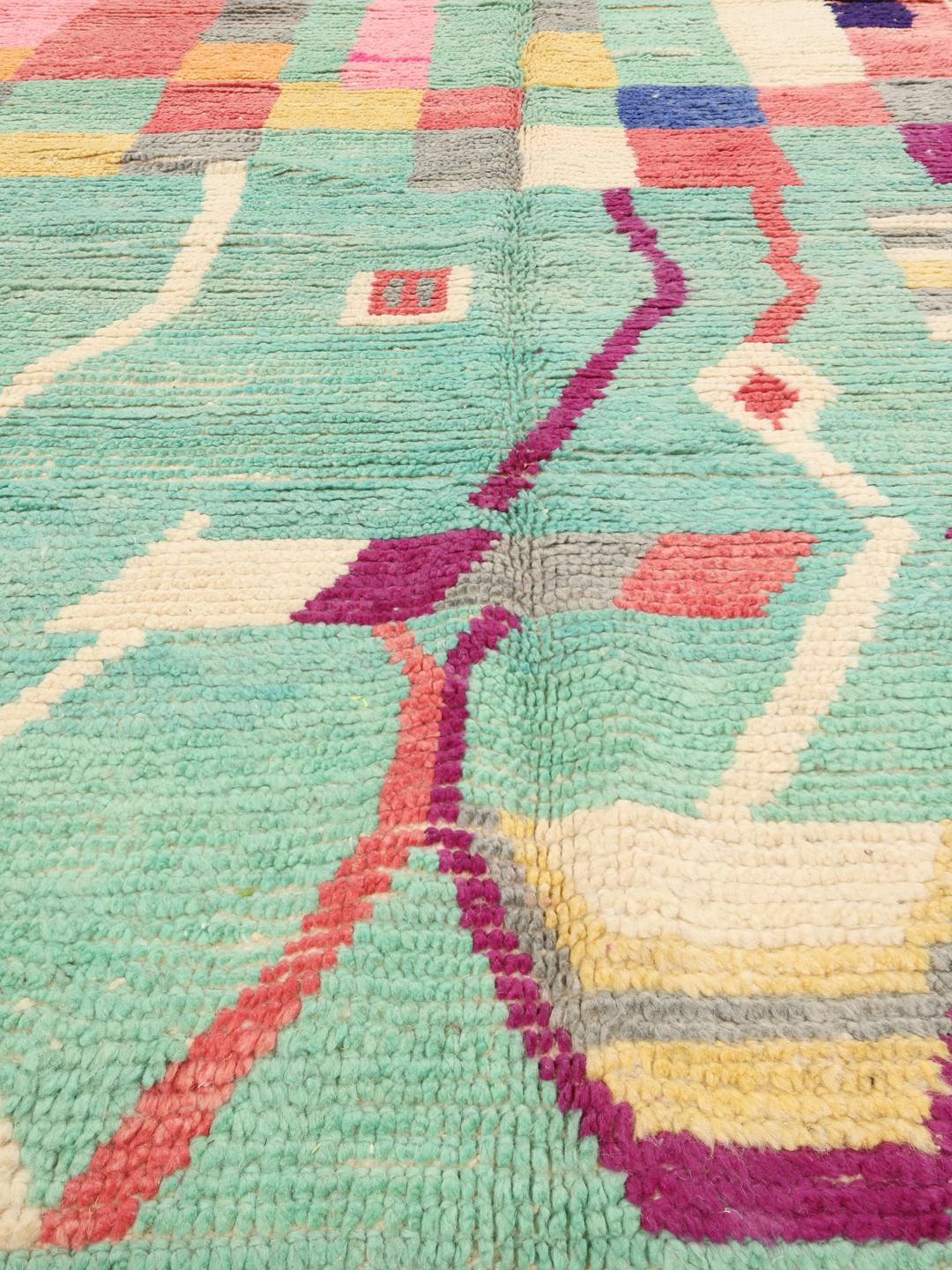 Handgeknoopt Marokkaans tapijt met een levendig veelkleurig geometrisch patroon op een groenblauwe achtergrond