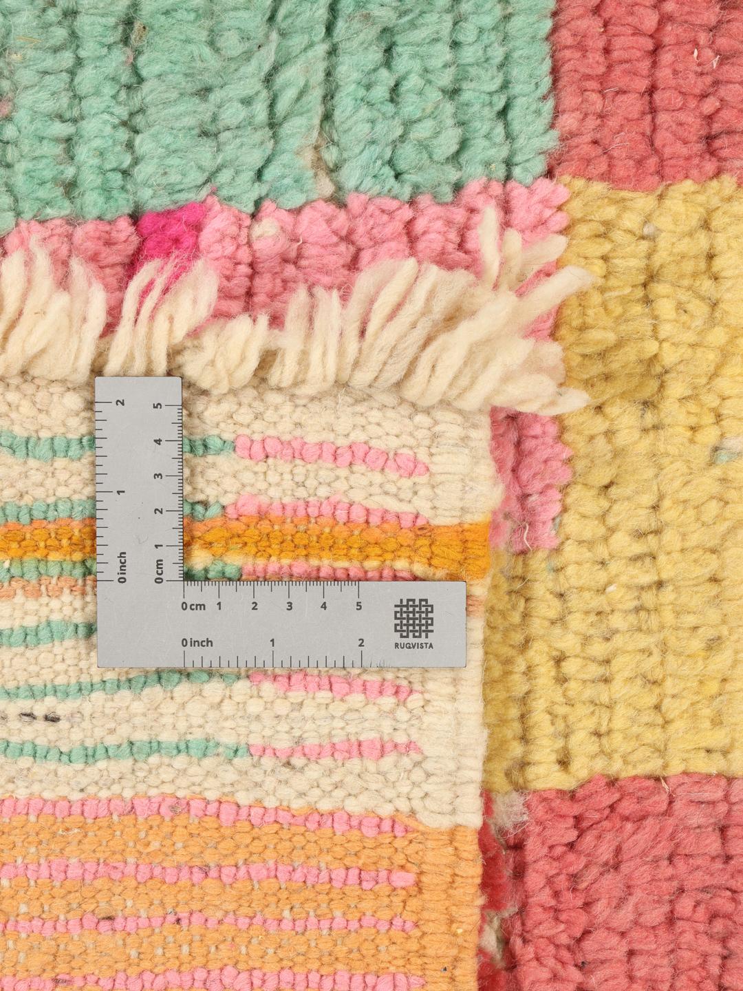 Handgeknoopt Marokkaans tapijt met een levendig veelkleurig geometrisch patroon op een groenblauwe achtergrond