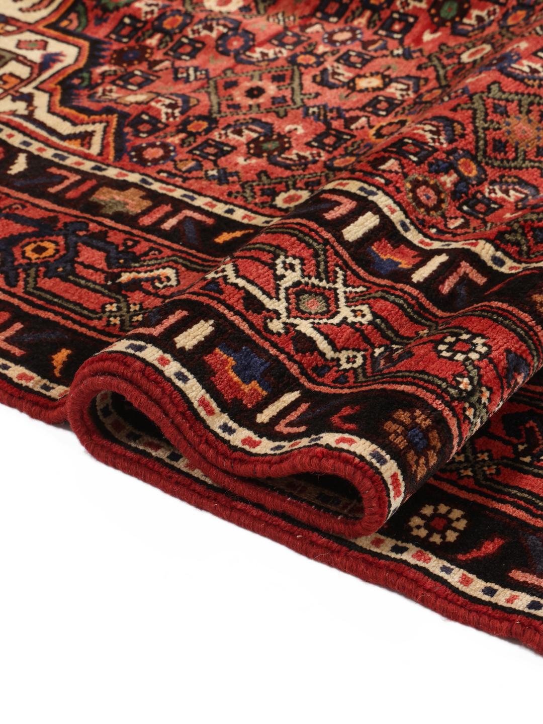 A hand-knotted Hosseinabad rug from the Middle East with a rich red field and central medallion.