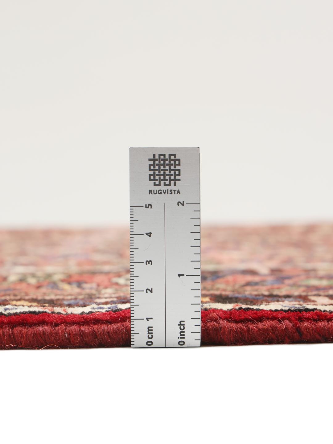 A hand-knotted Hosseinabad rug from the Middle East with a rich red field and central medallion.