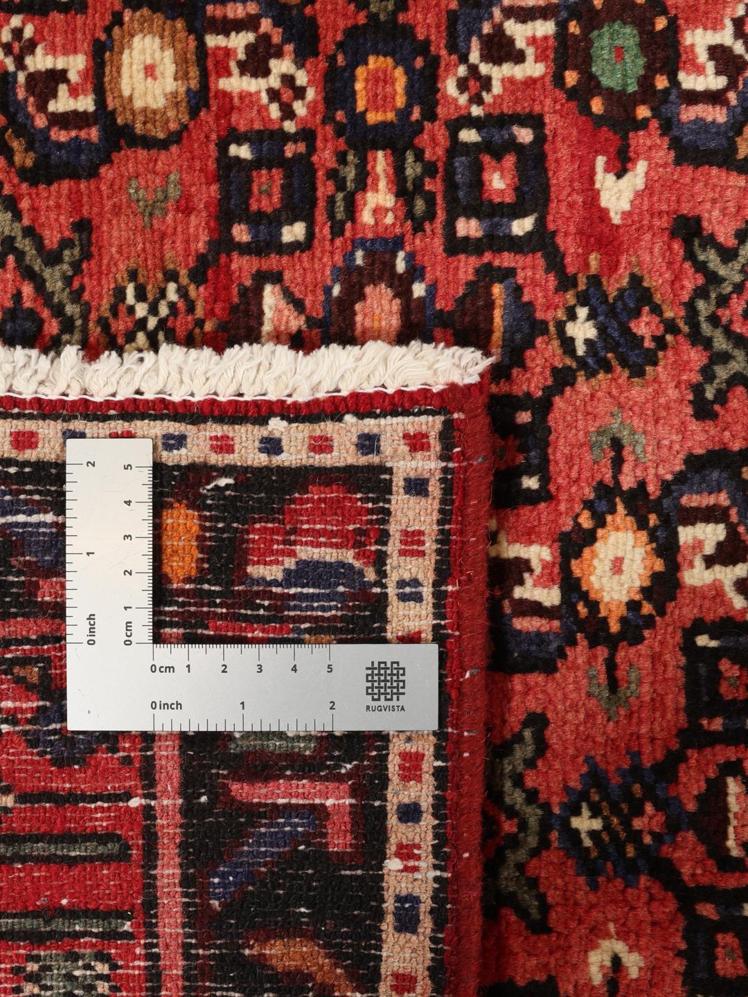 A hand-knotted Hosseinabad rug from the Middle East with a rich red field and central medallion.