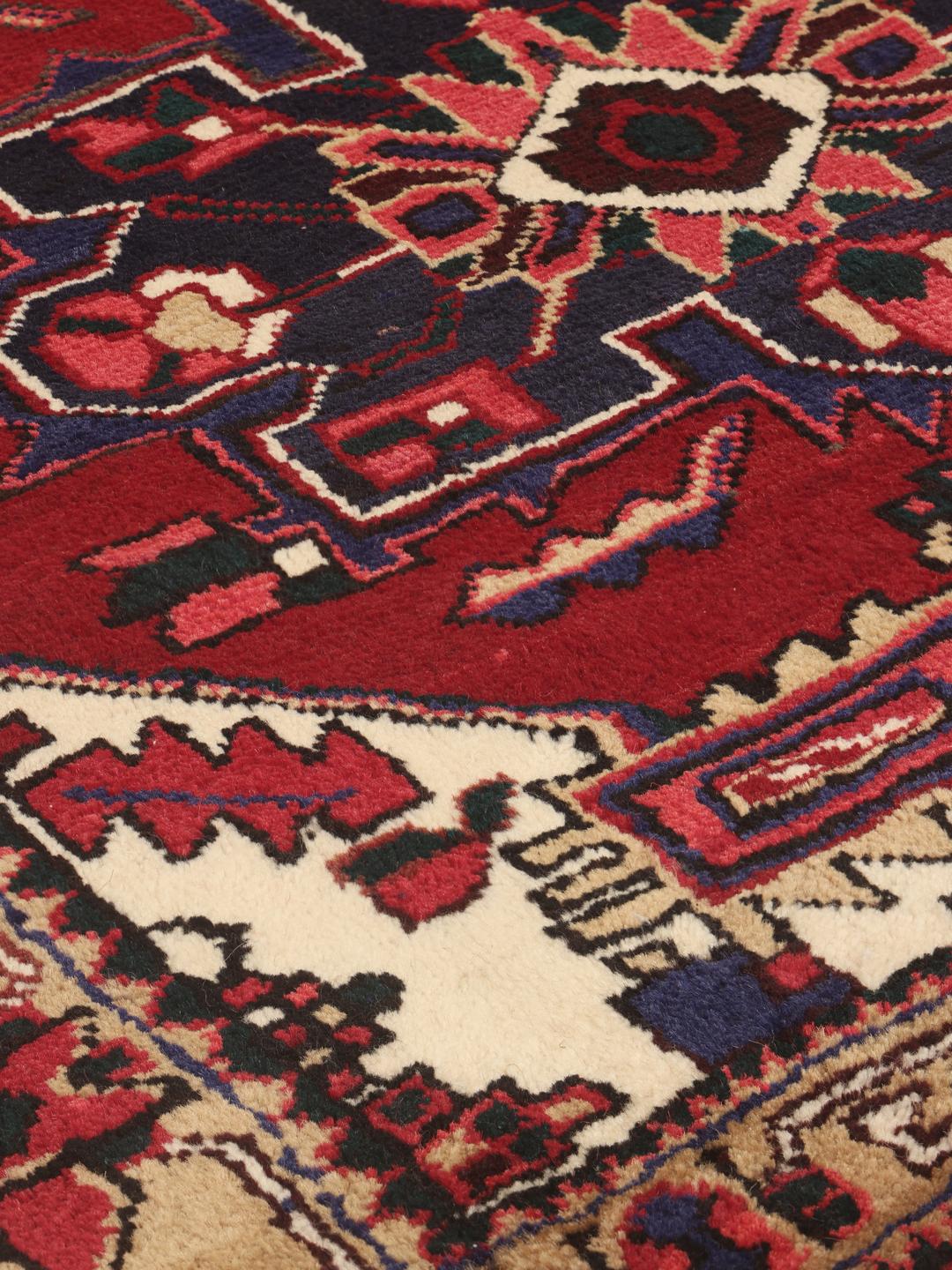 A hand-knotted Hamadan runner with traditional geometric red motifs