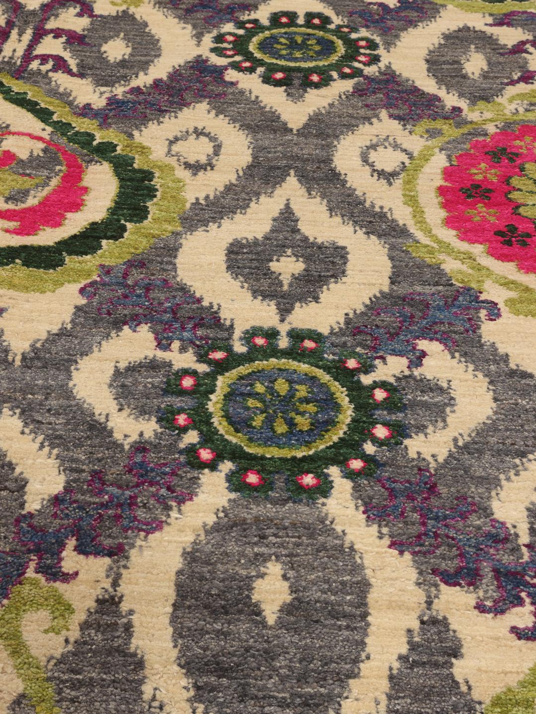 Un tapis afghan noué à la main présentant un motif floral et géométrique multicolore vibrant.