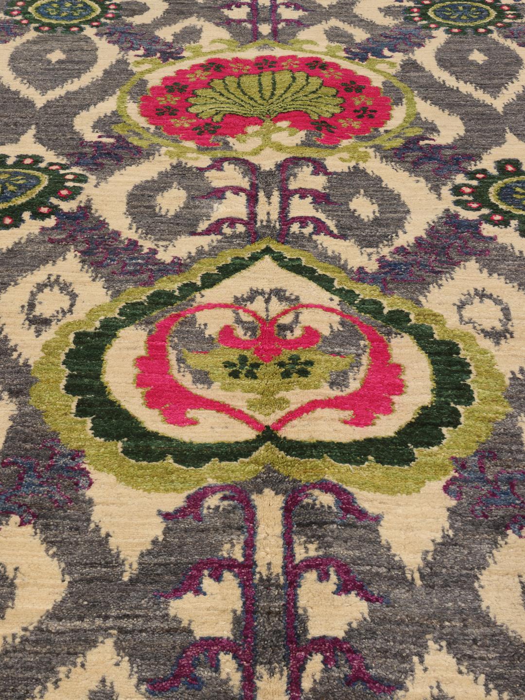 Un tapis afghan noué à la main présentant un motif floral et géométrique multicolore vibrant.