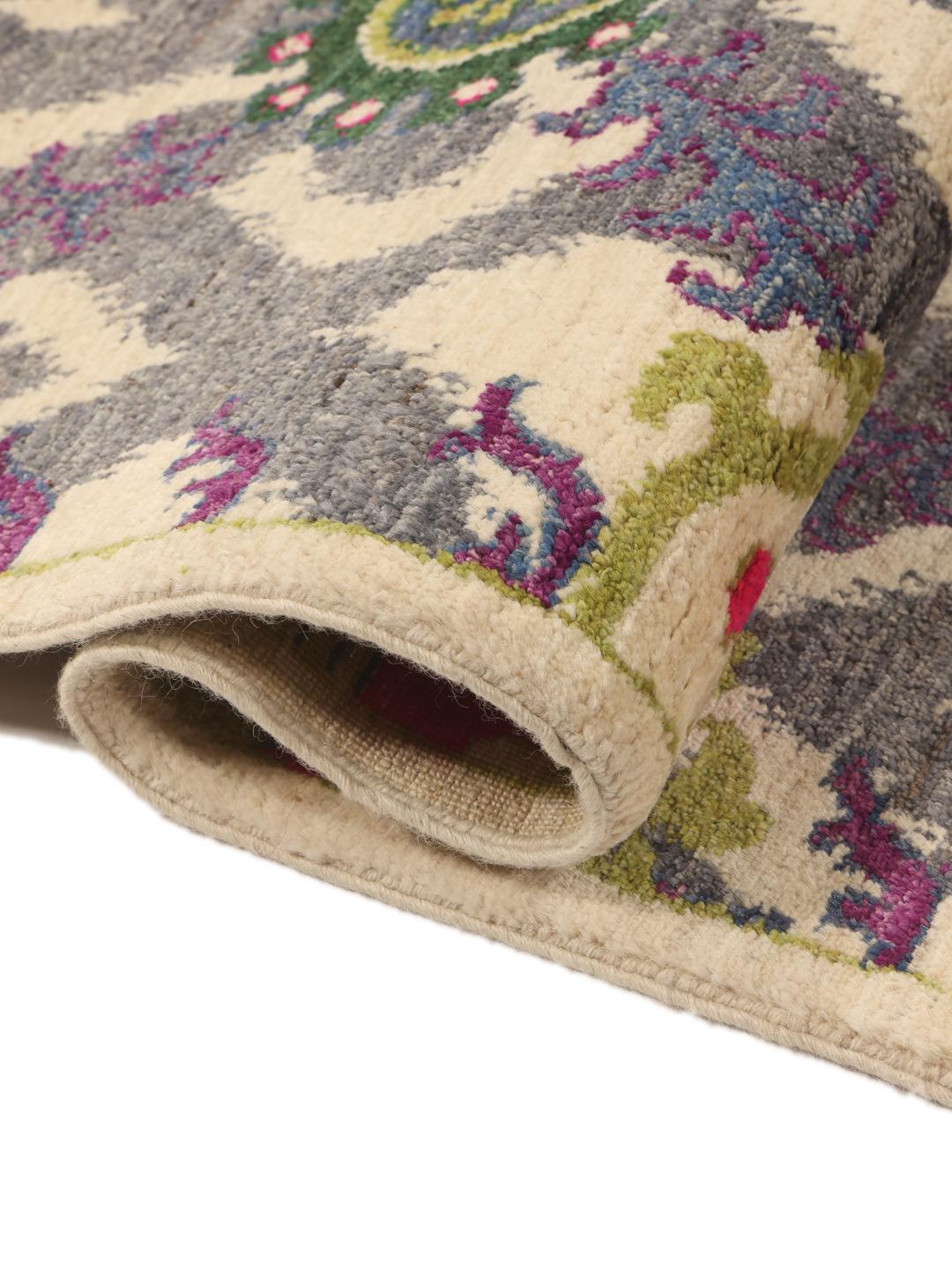 Un tapis afghan noué à la main présentant un motif floral et géométrique multicolore vibrant.