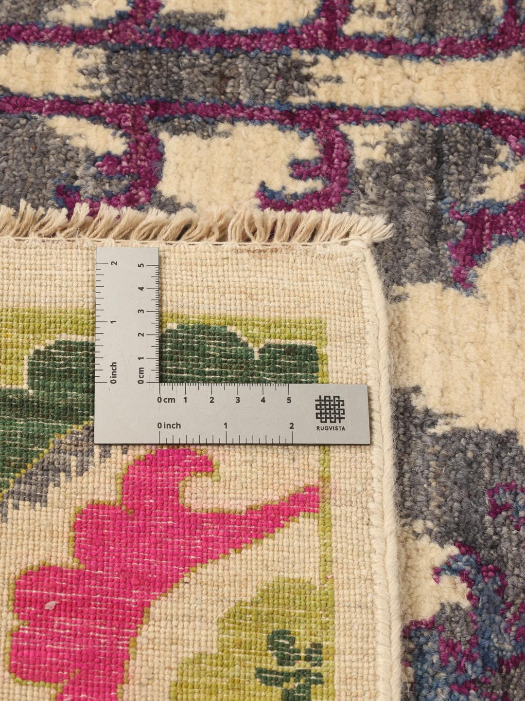 Un tapis afghan noué à la main présentant un motif floral et géométrique multicolore vibrant.