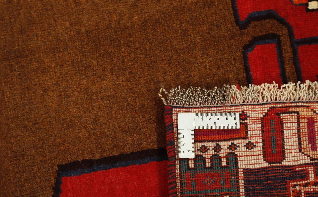 A red rectangular Qashqai rug with two brown lion motifs from the Middle East.