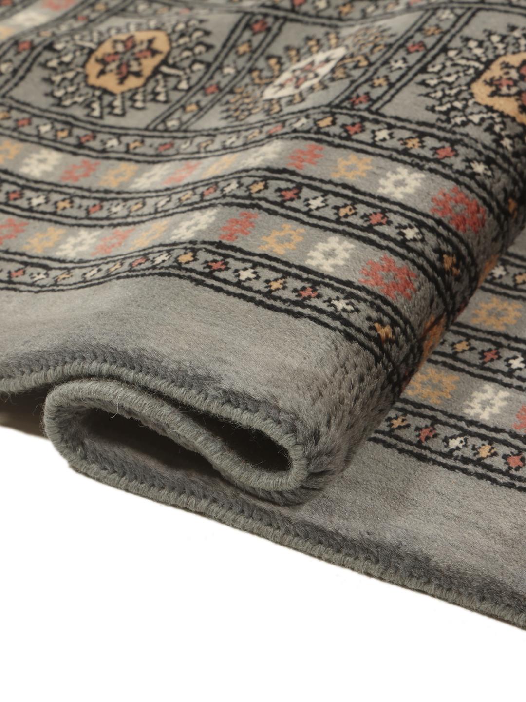 A hand-knotted Pakistan Bokhara rug in grey with traditional repeating motifs.