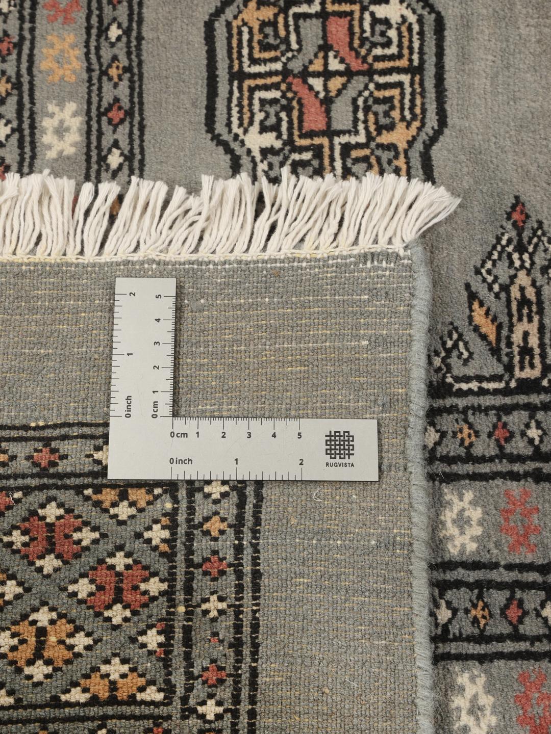 A hand-knotted Pakistan Bokhara rug in grey with traditional repeating motifs.