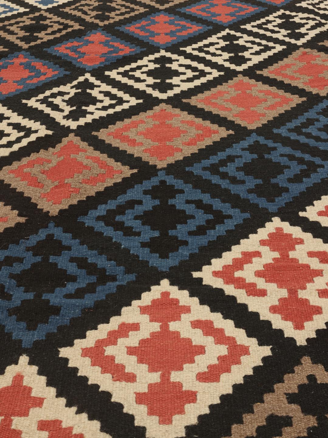 Handgeweven Ghashghai-kelimkleed met veelkleurige geometrische patronen op een zwart veld.