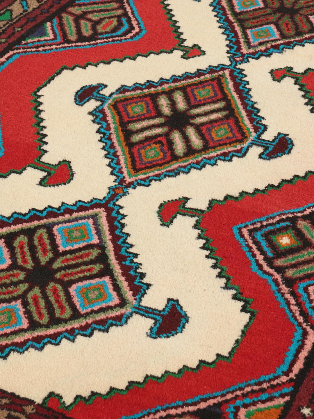 Hand-knotted Asadabad rug from the Middle East featuring a vibrant red, white, and multicolor geometric design.
