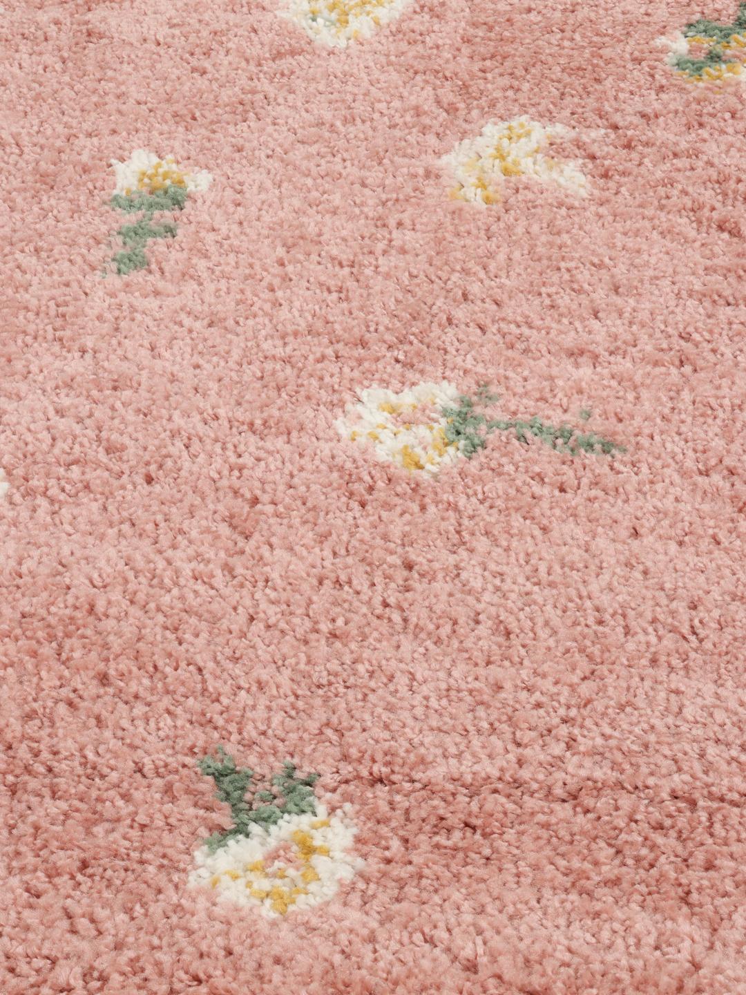 Rundt lyserødt tæppe med blomstermotiver og frinzer