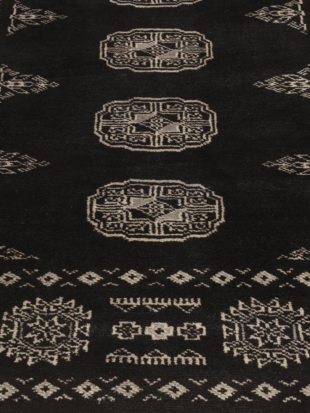Hand-knotted Pakistan Bokhara rug with black field and geometric motifs