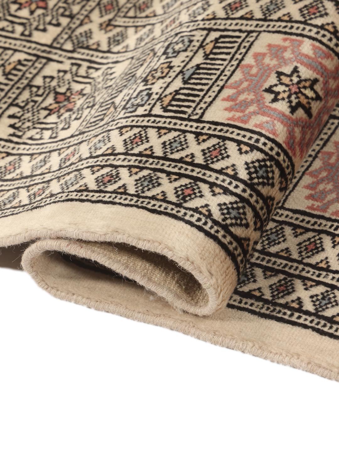 Een handgeknoopt Pakistan Bokhara tapijt met een beige veld en traditionele motieven.