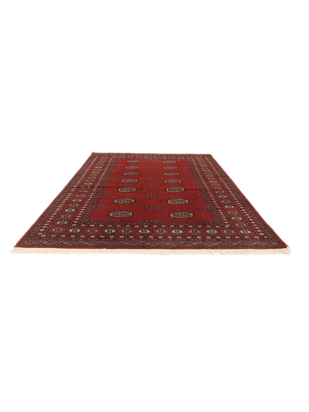 Un tapis Pakistan Bokhara noué à la main avec un champ rouge profond et des motifs géométriques répétitifs.