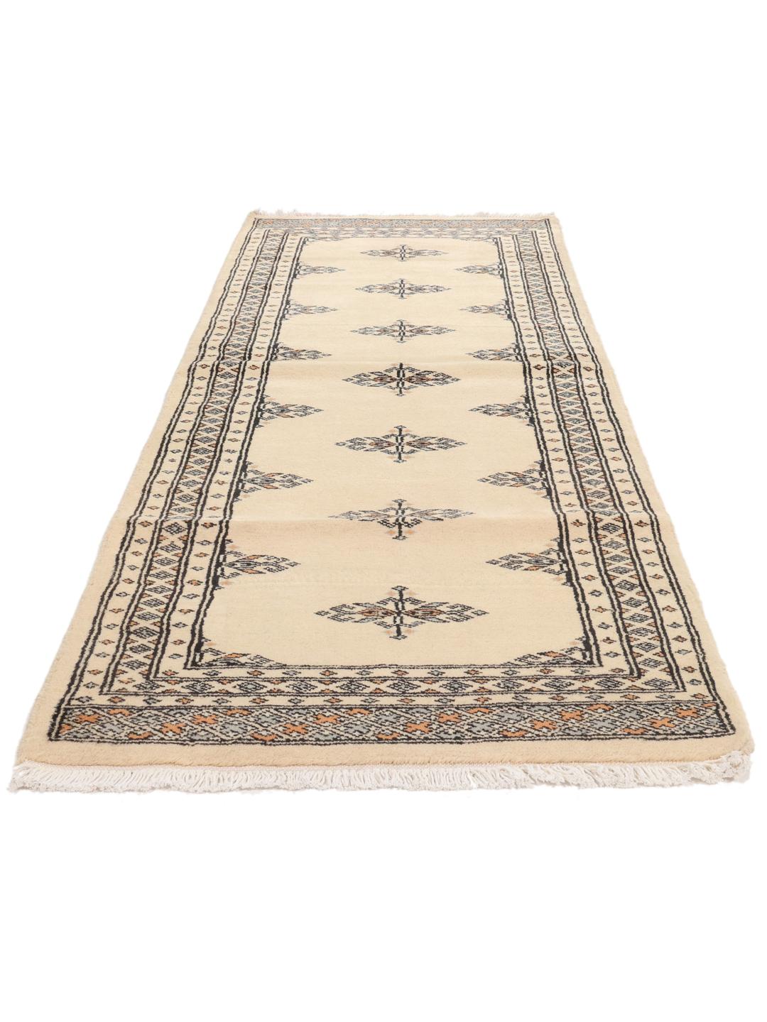 A hand-knotted Pakistani runner rug in beige with a traditional tribal pattern.