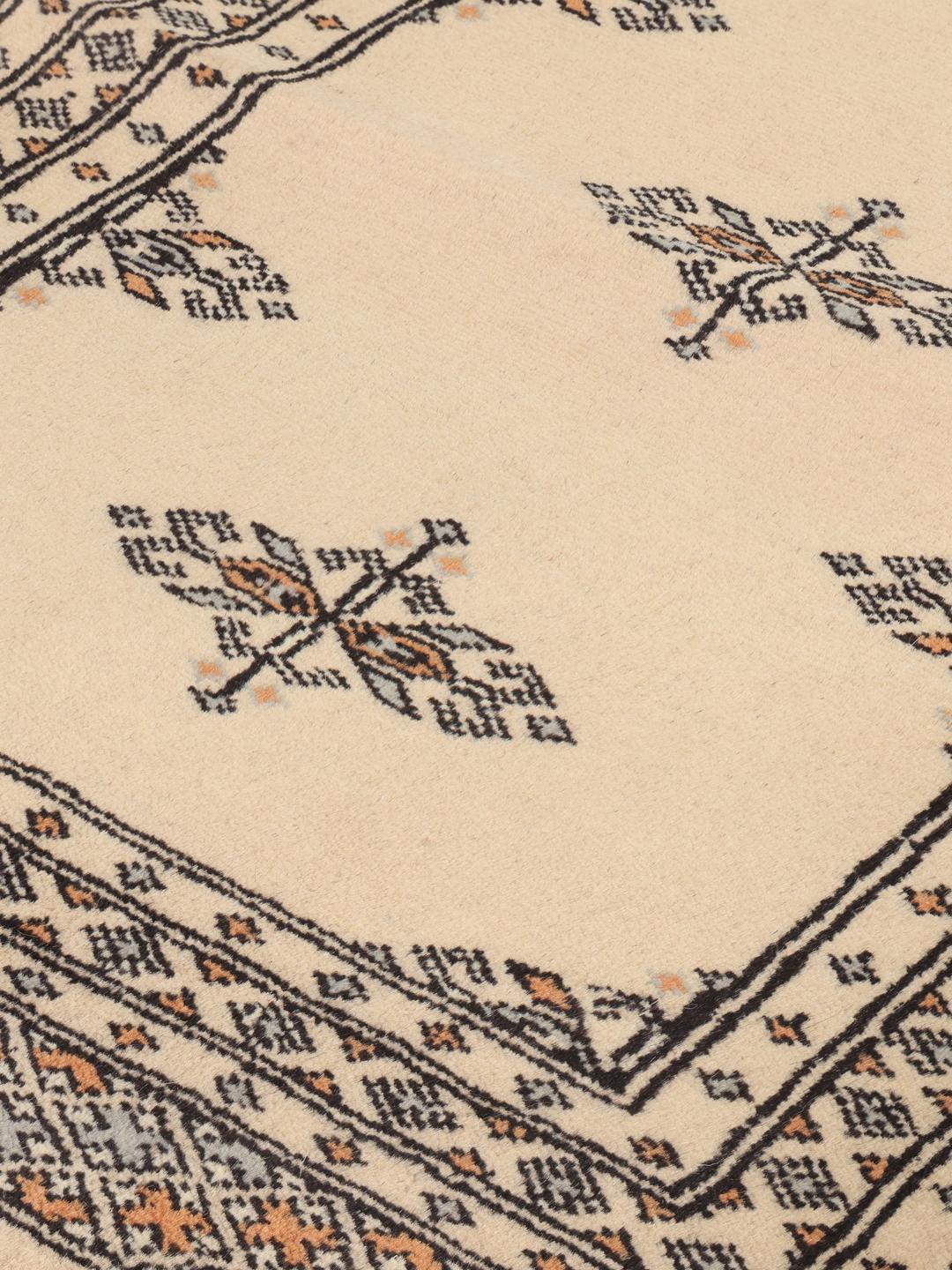 A hand-knotted Pakistani runner rug in beige with a traditional tribal pattern.