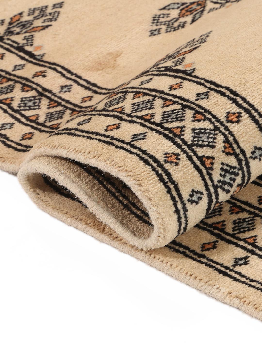 A hand-knotted Pakistani runner rug in beige with a traditional tribal pattern.