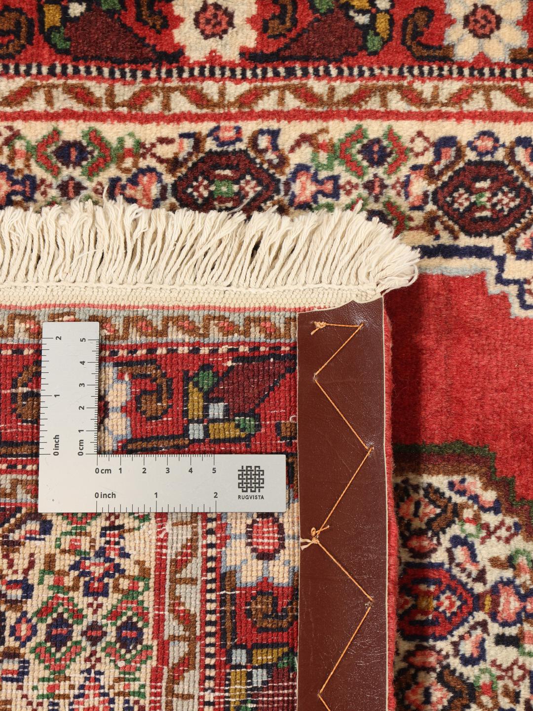 A hand-knotted Senneh rug from the Middle East in vibrant red tones.