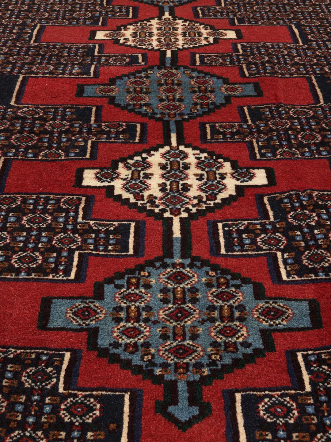 Hand-knotted Senneh runner with a geometric pattern in red and blue tones from the Middle East