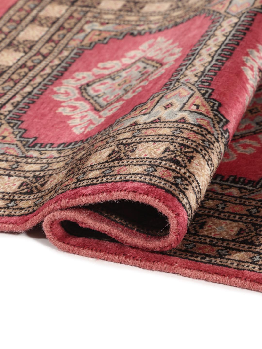 A small, rectangular Pakistan Bokhara 2ply rug in dark-red with geometric medallions.