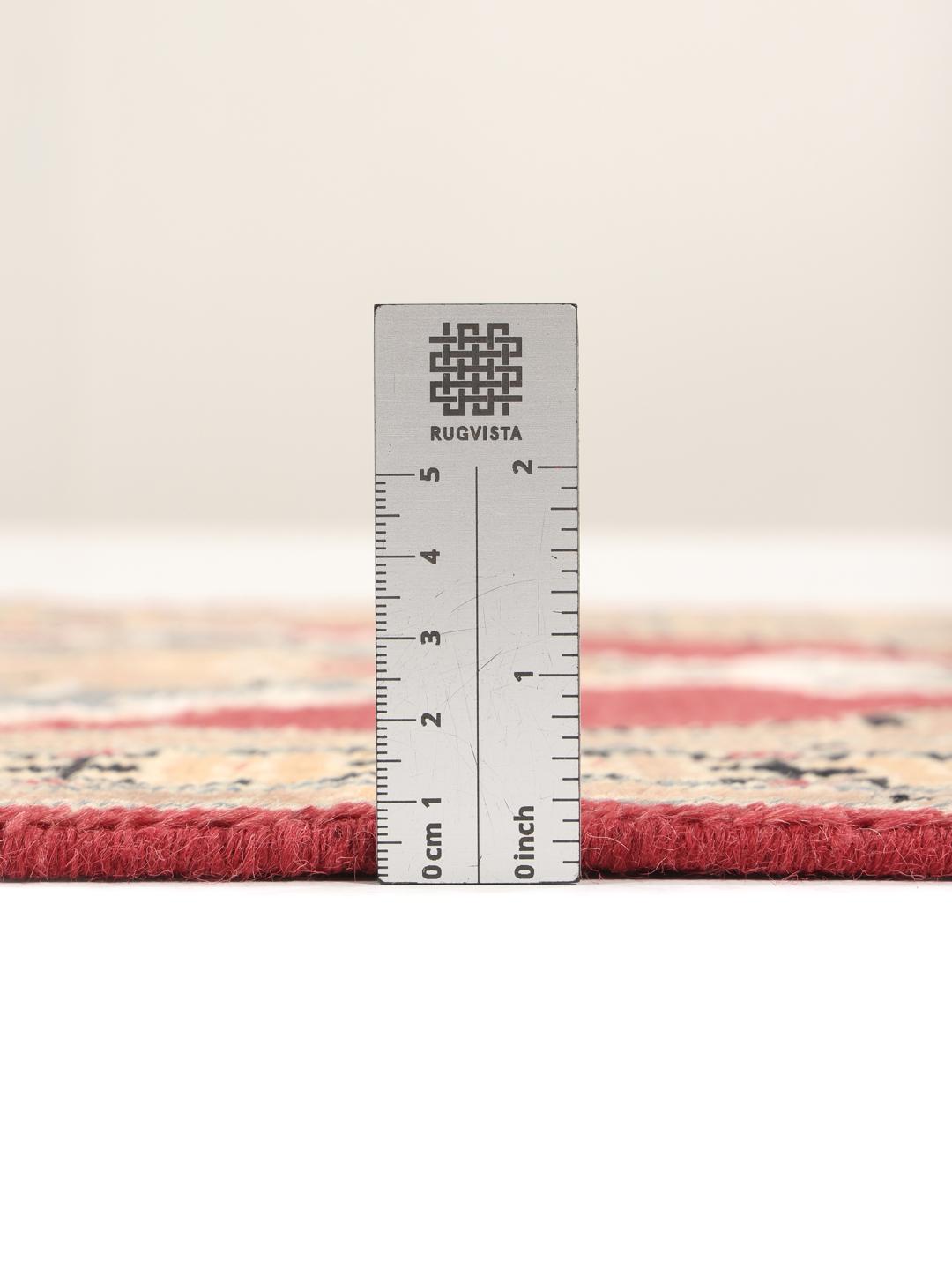 A hand-knotted Pakistan Bokhara wool rug featuring a red and beige geometric design.