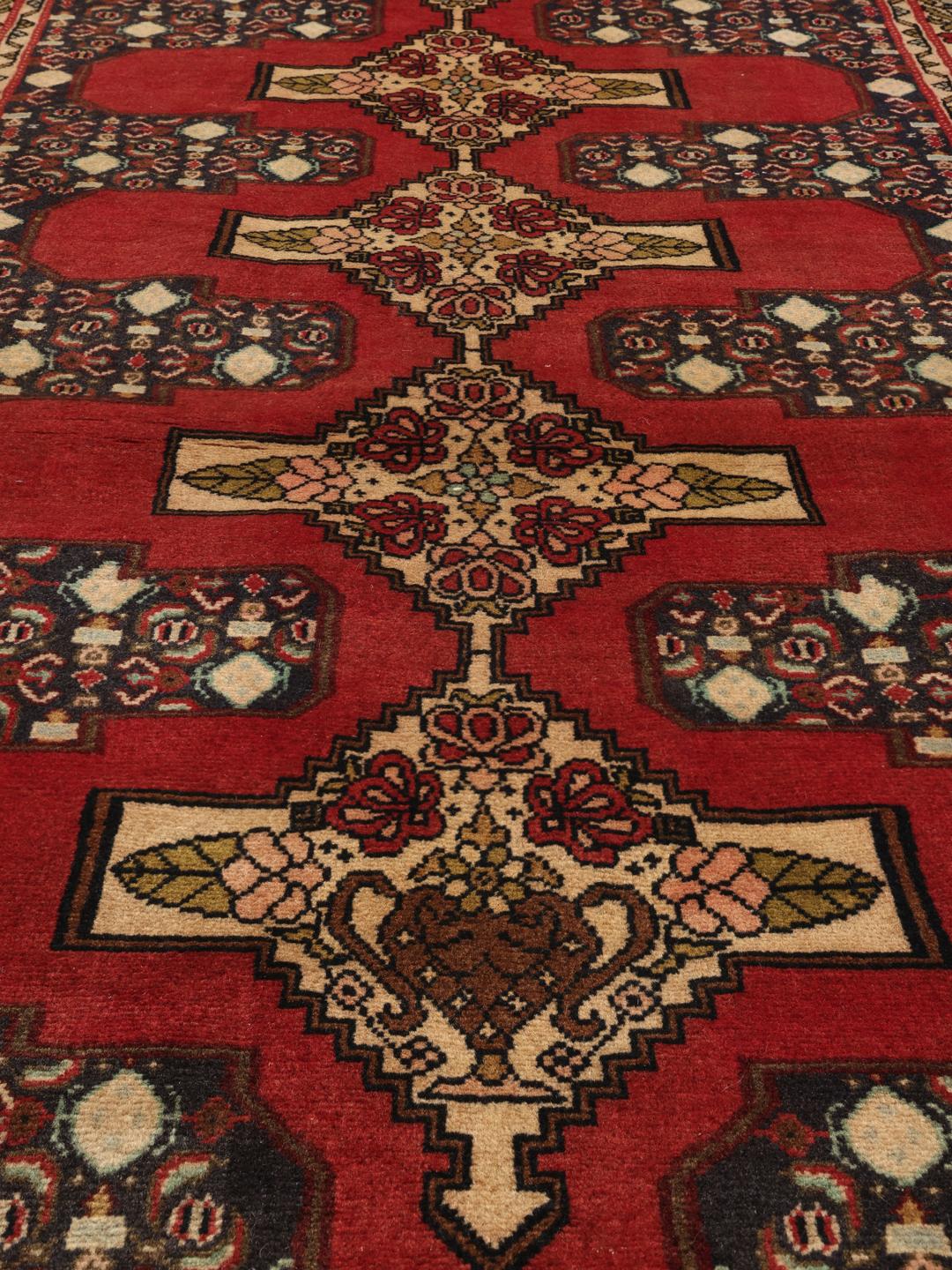 Hand-knotted Senneh runner from the Middle East in shades of red and dark blue.