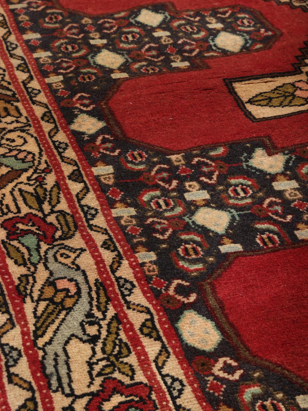 Hand-knotted Senneh runner from the Middle East in shades of red and dark blue.