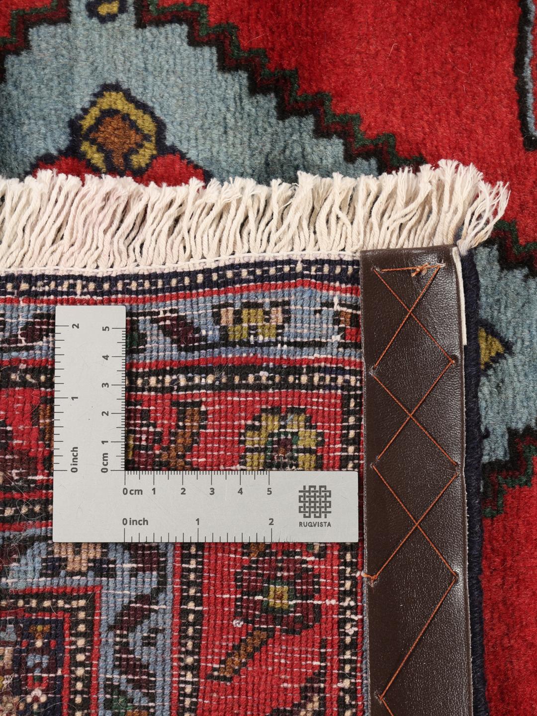 Hand-knotted Senneh runner with a red field and decorative medallion pattern