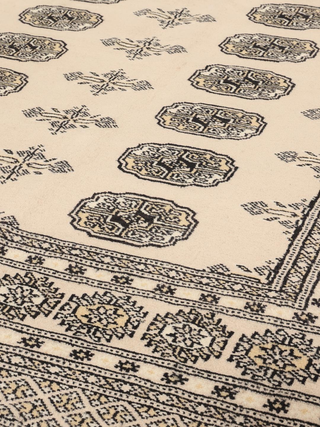 Hand-knotted beige Pakistan Bokhara rug with traditional repeating motifs