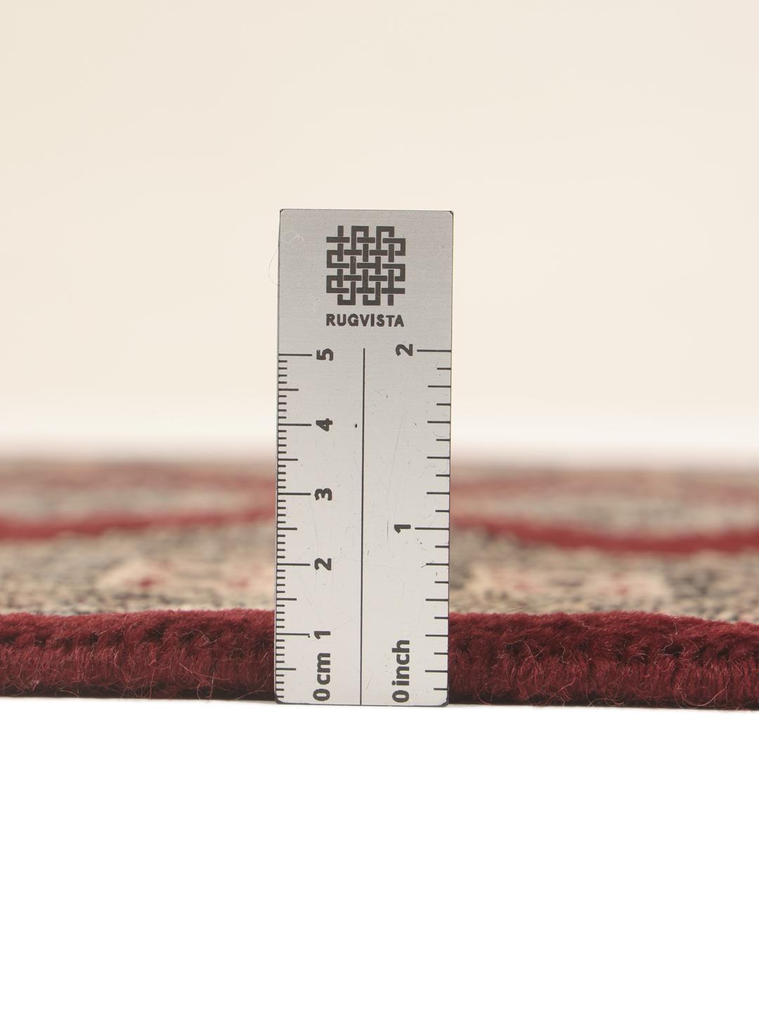 A hand-knotted Pakistan Bokhara rug featuring geometric medallions in dark-red and beige.