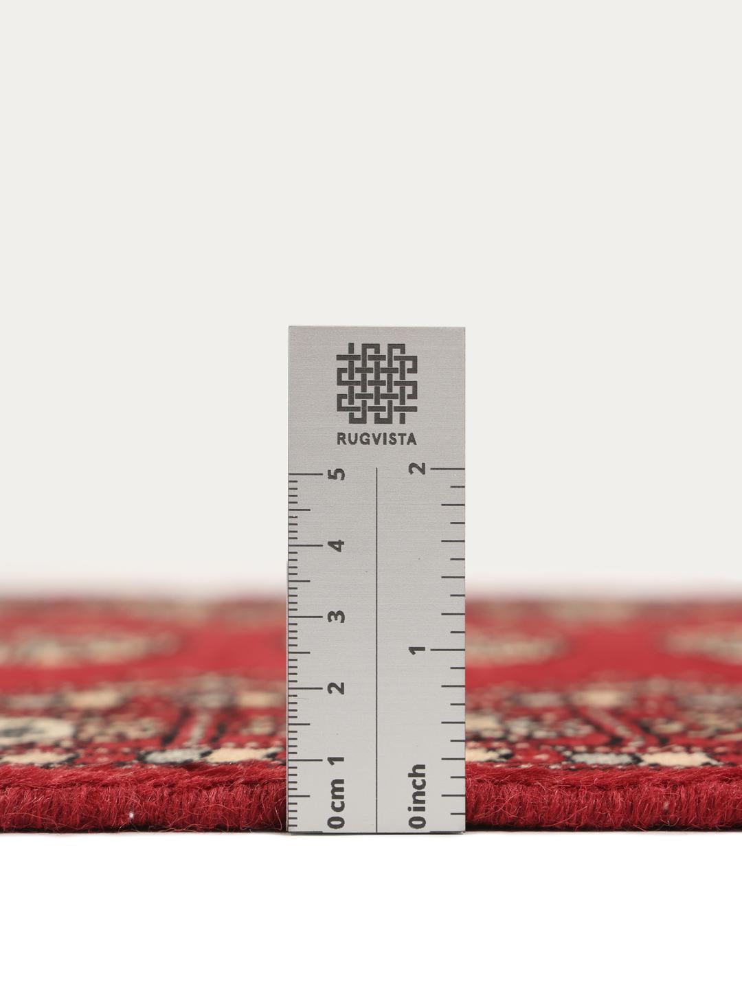 A hand-knotted Pakistan Bokhara rug with a dark-red field and classic repeating motifs.