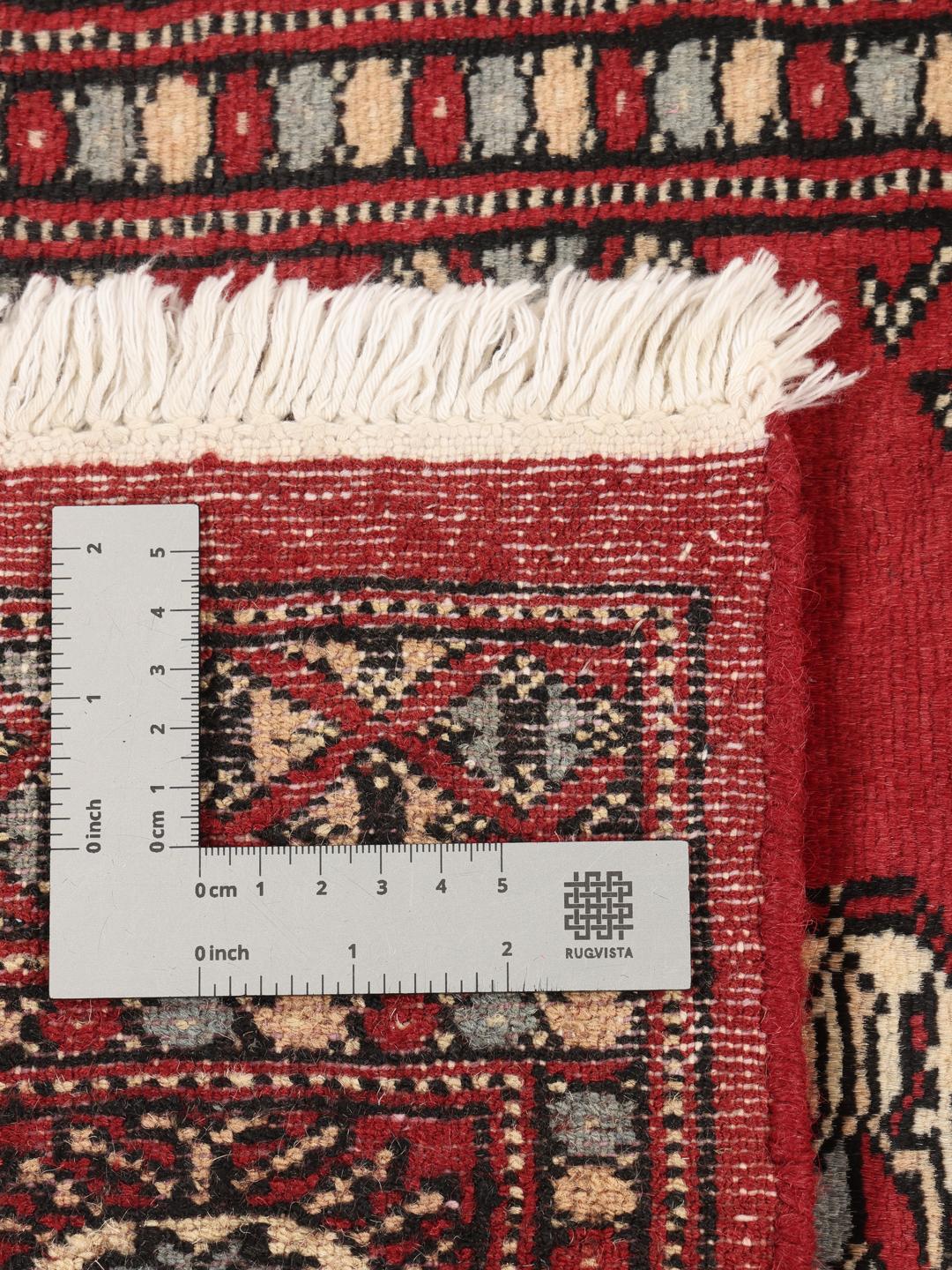 A hand-knotted Pakistan Bokhara rug with a dark-red field and classic repeating motifs.