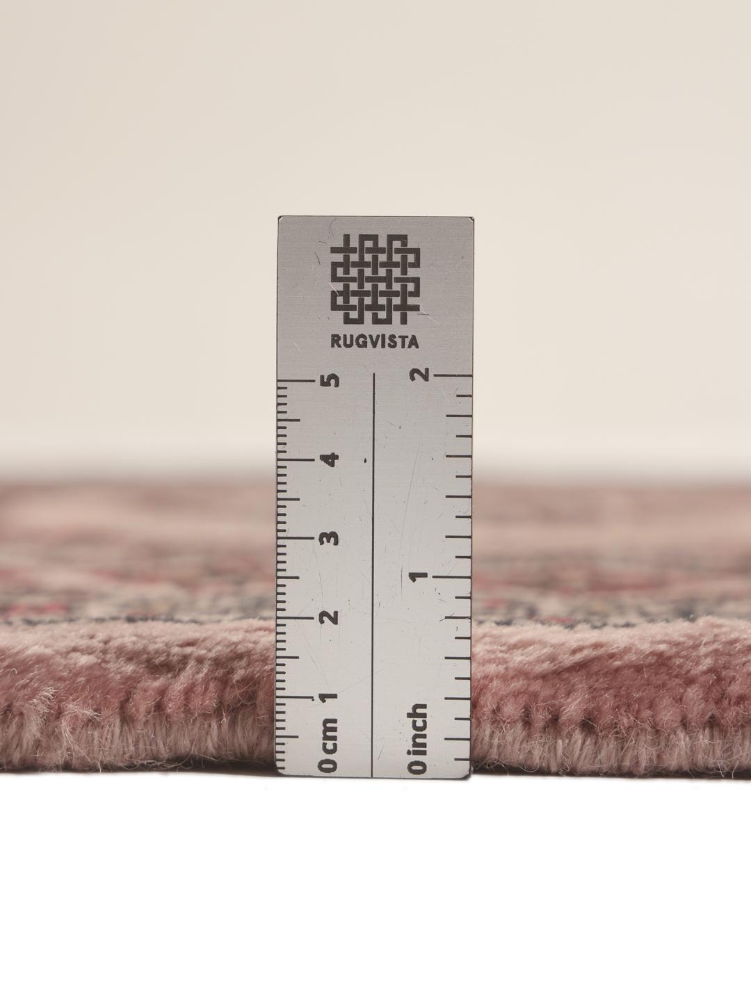 Een rechthoekig handgemaakt Pakistan Bokhara 3ply tapijt in roze met geometrische medaillonpatronen.