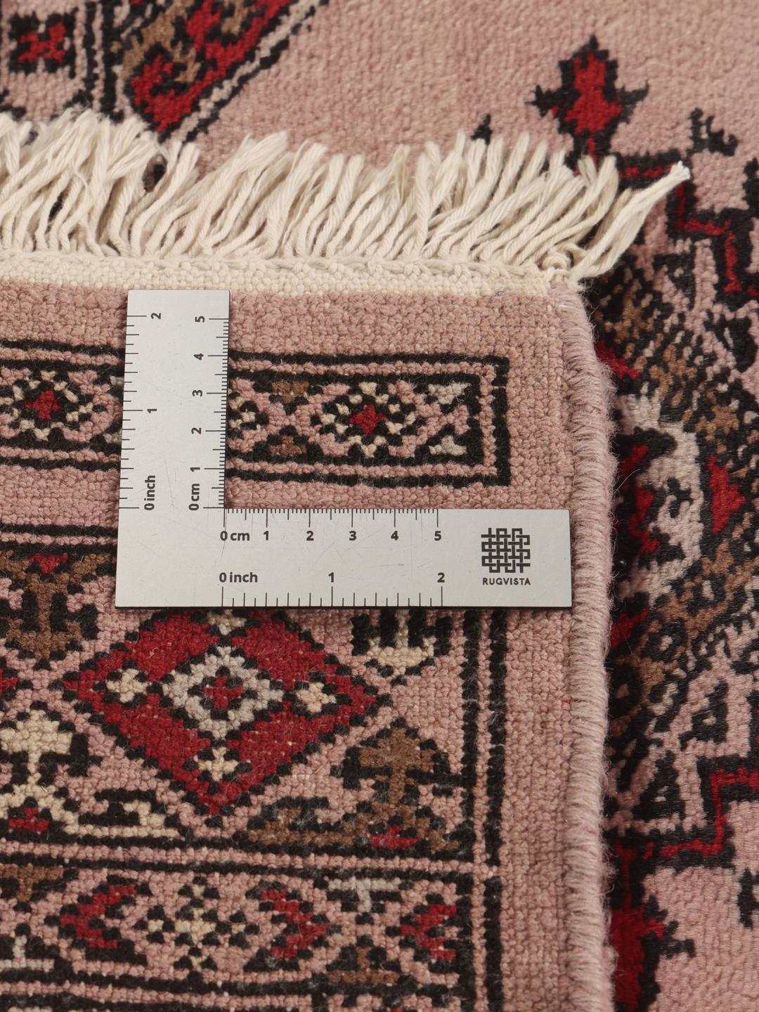 Een rechthoekig handgemaakt Pakistan Bokhara 3ply tapijt in roze met geometrische medaillonpatronen.