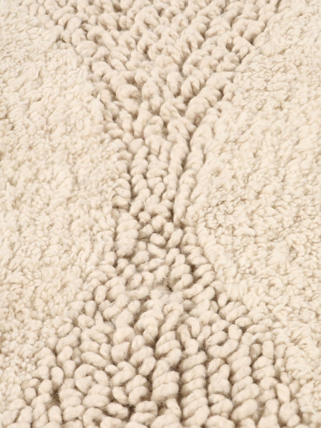 Tapis de bain rond beige avec un motif en relief ondulé texturé
