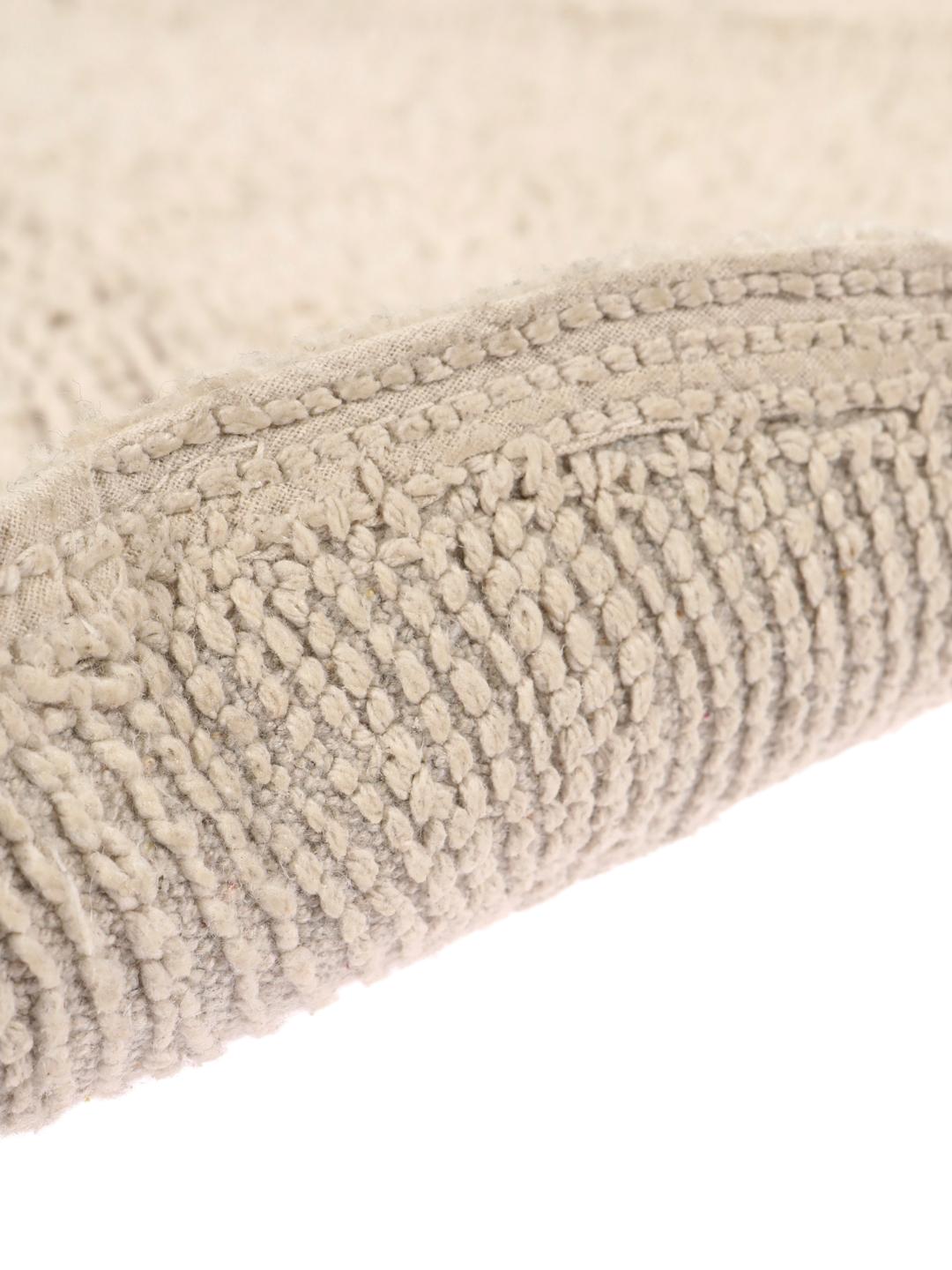 Rund beige bademåtte med et tekstureret bølget reliefmønster
