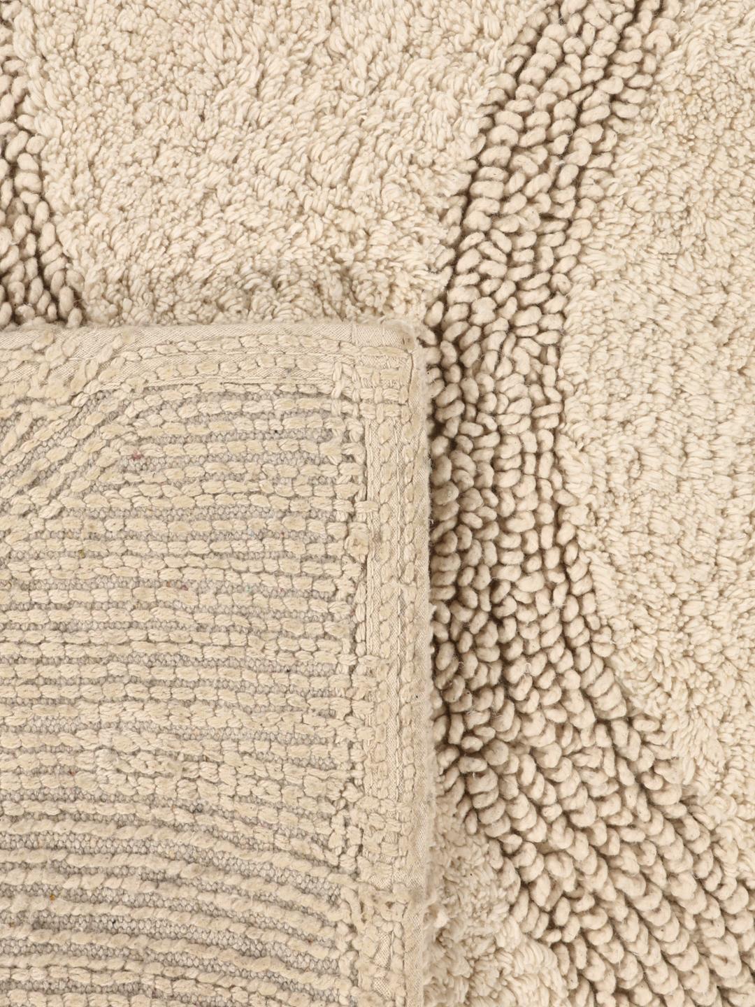 Beige bademåtte med et tekstureret bølget stribemønster