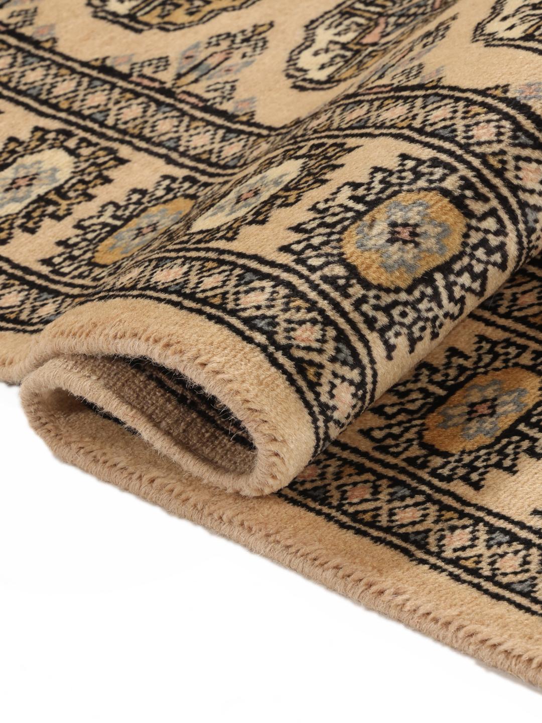 A hand-knotted Pakistan Bokhara rug with a beige field and traditional geometric motifs.