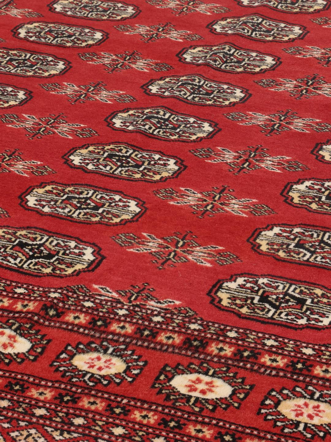Hand-knotted Pakistan Bokhara 2ply rug with a deep red field and traditional motifs