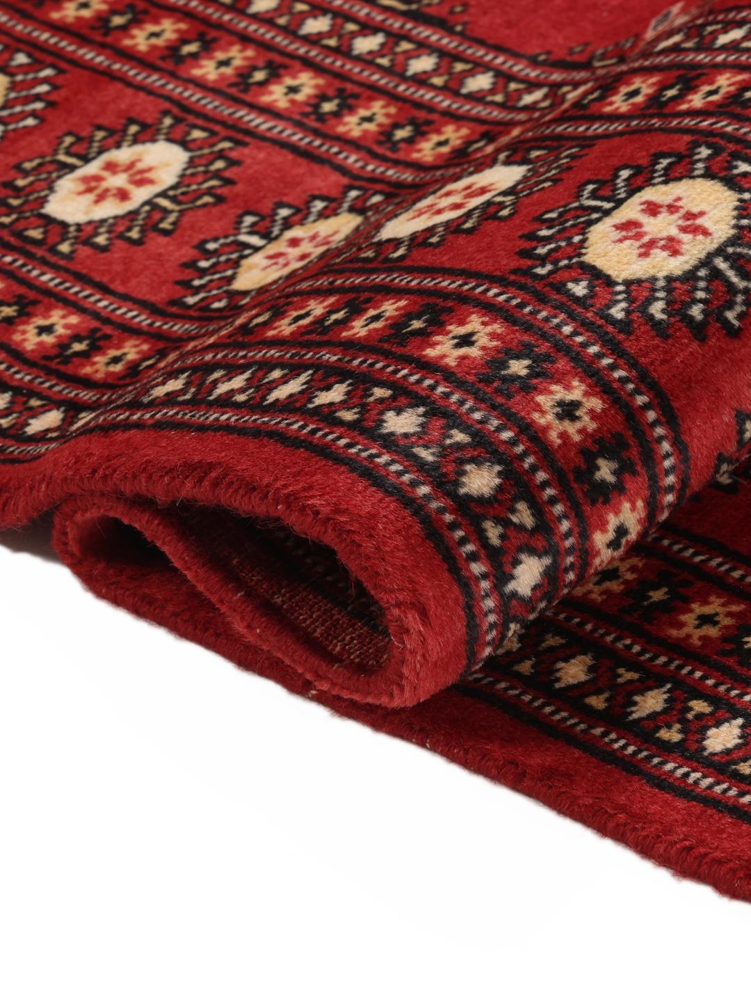 Hand-knotted Pakistan Bokhara 2ply rug with a deep red field and traditional motifs