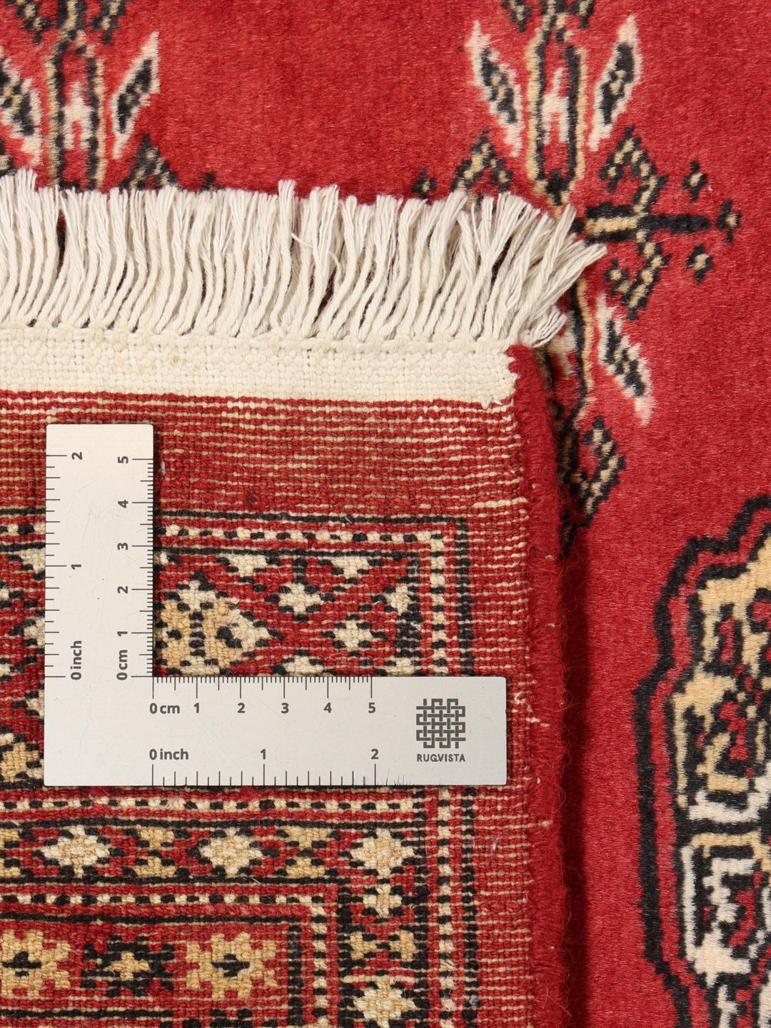 Hand-knotted Pakistan Bokhara 2ply rug with a deep red field and traditional motifs