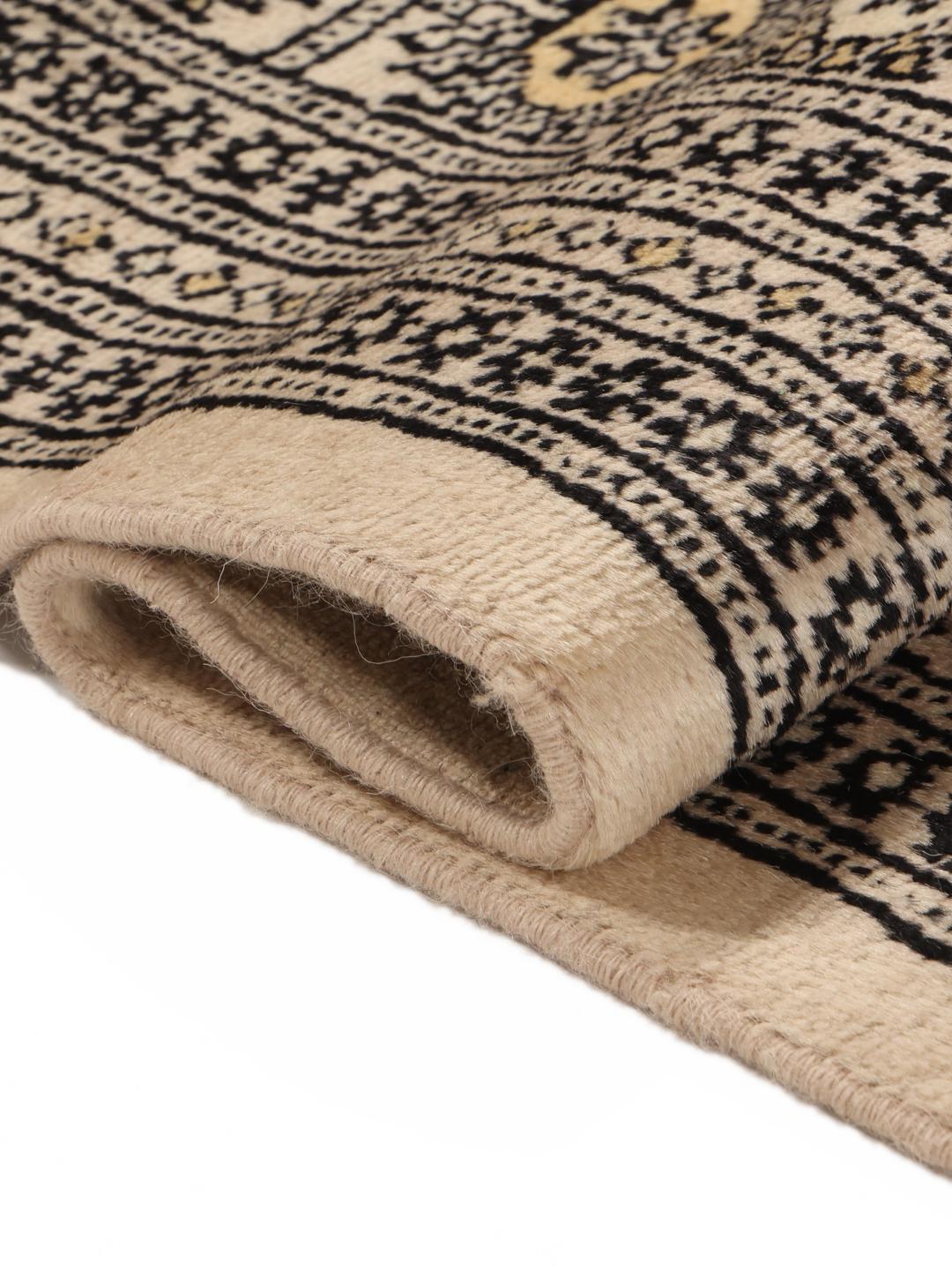 Een handgeknoopt Pakistan Bokhara tapijt met een beige veld en traditionele motieven.