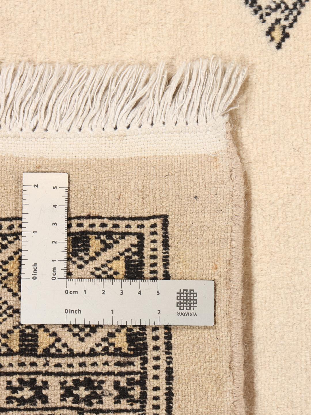 Een handgeknoopt Pakistan Bokhara tapijt met een beige veld en traditionele motieven.